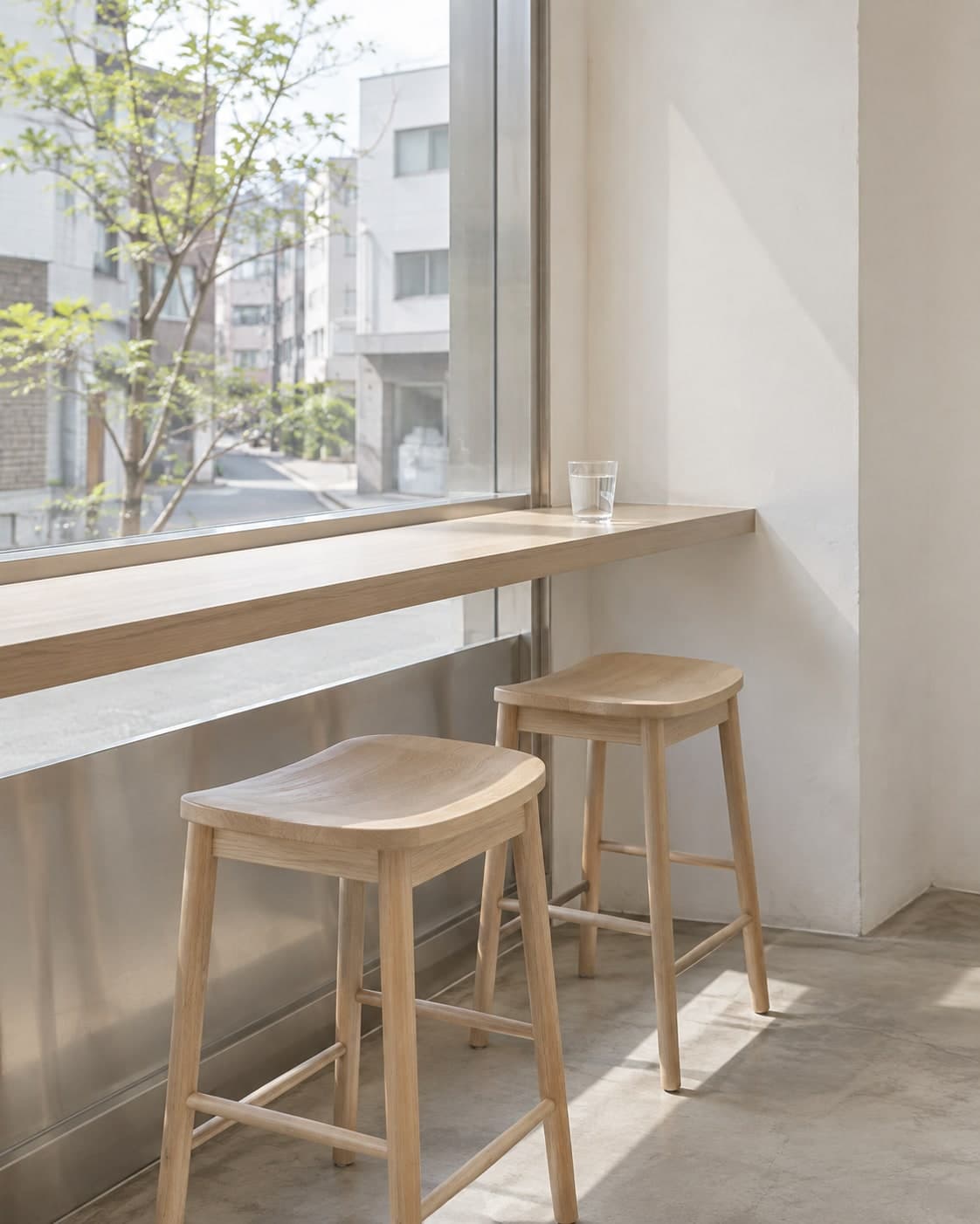 Two stools at the oak bar beside a silver window frame