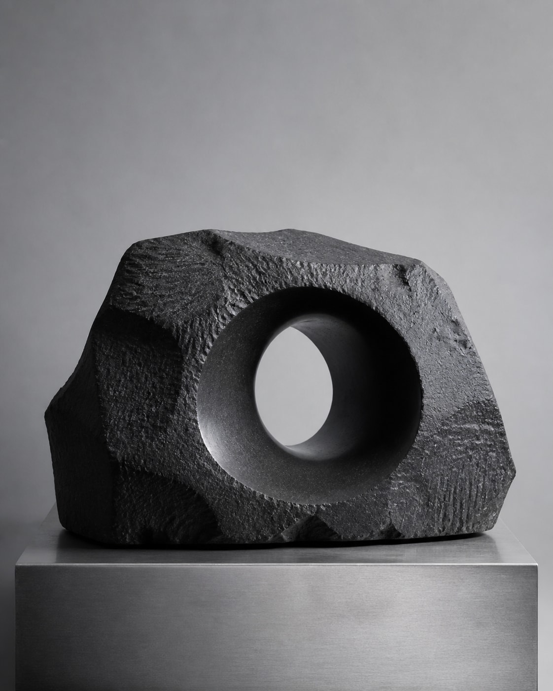 Carved basalt sculpture with a circular void